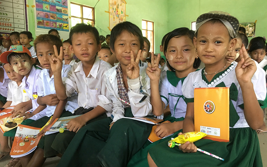 ノートと鉛筆をもらって喜ぶアシュエー村小学校児童